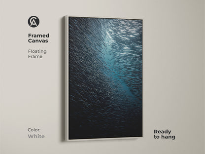 Framed canvas showcasing deep sea wildlife in a white floating frame. The teal blue ocean photography captures a school of fish underwater. This coastal wall art is a realistic marine life print. Ready to hang for a serene touch.