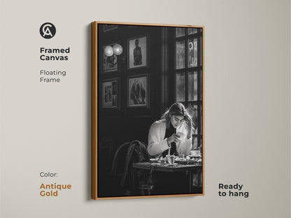 Antique gold framed canvas of a monochrome cafe scene. The contemporary black and white photojournalism style artwork features a woman with coffee. Ready to hang with a floating frame. Ideal for art collectors and those seeking a unique housewarming gift.