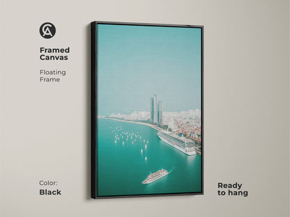 Framed canvas with a black floating frame features aerial cruise ship wall art. The teal ocean cityscape includes sailboats and a modern city view. This contemporary artwork is ready to hang and ideal for living room canvas decor.