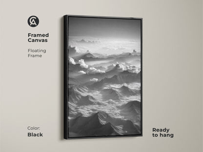 Framed canvas featuring black and white mountain artwork. This minimalist cloudscape wall decor is ready to hang. The contemporary nature art has a black floating frame. It is high altitude artwork.