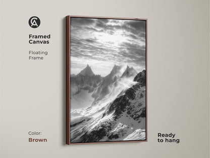Framed canvas displaying monochrome mountain art. The snowy peaks canvas print is set in a floating brown frame. This black and white landscape enhances any room. Nature wall decor complements modern interiors.