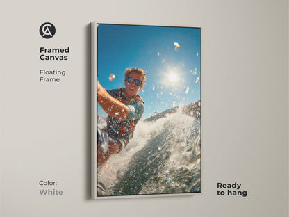 Framed canvas art of a surfer riding a wave is displayed. The white floating frame offers a clean modern look. Ready to hang this piece brightens any space. It's perfect for adding a fresh touch of action to your wall art.