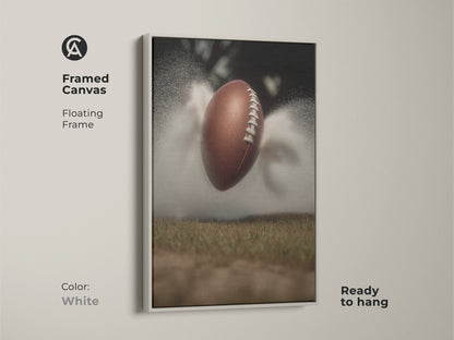 This dynamic football art print is framed in white. It captures the raw energy of sports action. This canvas wall decor is perfect for a modern office or man cave. A great gift for any sports lover. The artwork features a textured football against a misty field bringing an athletic touch.
