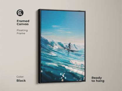 A framed canvas art capturing a surfer riding a powerful blue wave. The black floating frame adds a touch of modern elegance. Ready to hang this artwork brings the excitement of surfing to any room. Perfect for adding a coastal vibe.
