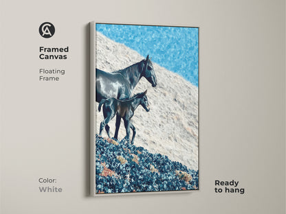 Framed canvas art shows a horse and foal in a floating frame. The rustic landscape canvas features a deep blue sky. This nature themed artwork is ready to hang in a white frame. The frame color is white.