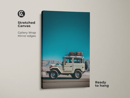 Stretched canvas gallery wrap showcasing a vintage SUV. The retro mountain landscape art has mirrored edges. It's ready to hang with teal sky blue decor. A perfect adventure photography print.