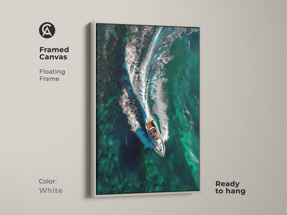 Framed canvas with a white floating frame displaying emerald ocean waves and a speedboat. Ready to hang this aerial view canvas art brings a coastal feel. An ideal gift for captain or boating enthusiasts.