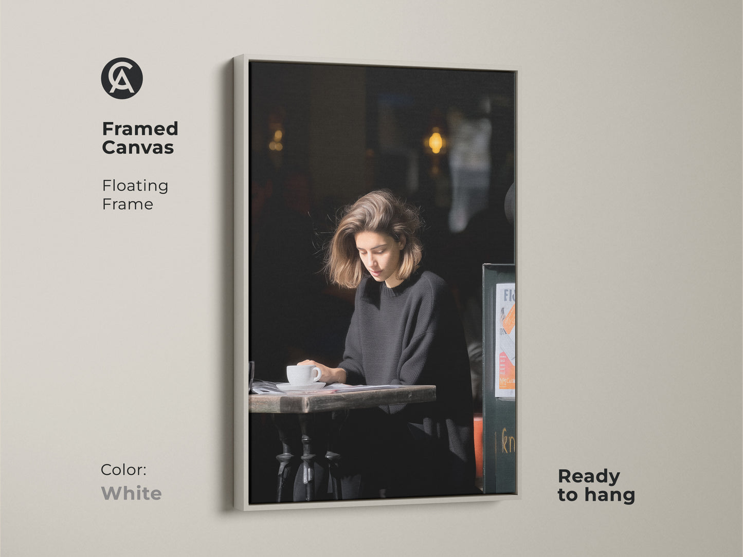 White framed canvas print. Features a woman reading at a cafe. A minimalist black and white art piece. A stylish addition to any modern home or office space.