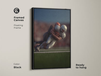 Framed canvas featuring a dynamic football tackle in a floating black frame. This photorealistic sports action wall art is ready to hang. Perfect for a man cave or den sports decor. A great gift for any football fan who loves team sports. Add an intense football moment to your space.