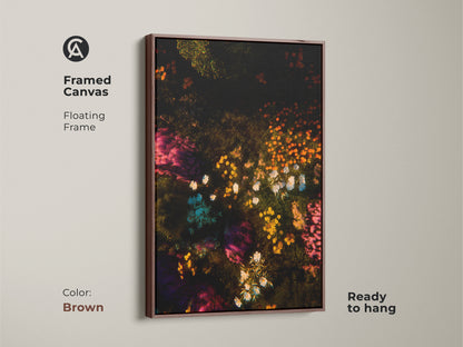 Framed canvas with a brown floating frame showcasing floral artwork. The art features a dark background with colorful flowers. Ready to hang this framed canvas is a great addition to your home decor. Its warm tones complement any room.