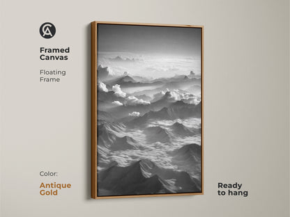 Framed canvas featuring a monochrome mountain print. It's a minimalist cloudscape wall decor with an antique gold floating frame. The contemporary nature art is ready to hang. It is a scenic aerial view.