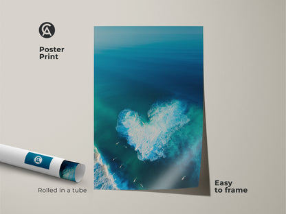 Poster print art featuring a stunning aerial view of the ocean. A heart-shaped wave is visible. Surfers are enjoying the waves. This high-quality poster is easy to frame. Rolled and shipped in a protective tube. Add a touch of coastal beauty to your home. 