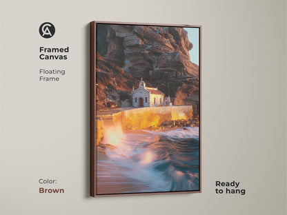 Brown framed canvas presents a coastal chapel photograph. The floating frame enhances the warm earth tones and teal landscape. Ready-to-hang ocean waves art brings Mediterranean charm. This is perfect beach house canvas art for coastal home decor.