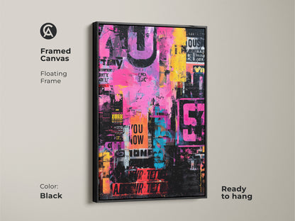 This is a framed canvas print of collage art. The artwork has pink yellow and blue colors. It features stenciled words and numbers. The frame is black and floating. This canvas is ready to hang.