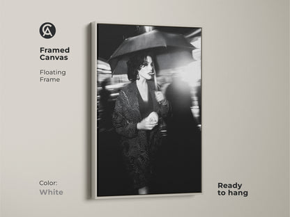 This framed canvas art with a white floating frame is ready to hang. It showcases a monochrome woman with umbrella. The street photography print adds urban chic. Transform your space with contemporary wall art. This black and white artwork is perfect for modern bedroom decor.