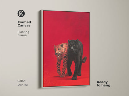 Framed canvas art showcases a black panther and leopard against a red backdrop. The floating frame is white and ready to hang. This artwork offers a clean and modern aesthetic to wildlife art. Elevate your home decor with this stunning and versatile piece.