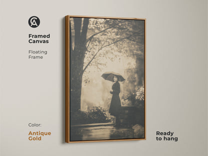 Framed canvas print featuring a woman with an umbrella. This floating frame art is in an antique gold finish. The ready-to-hang artwork adds a touch of luxury. Antique gold frame complements the monochrome artwork.