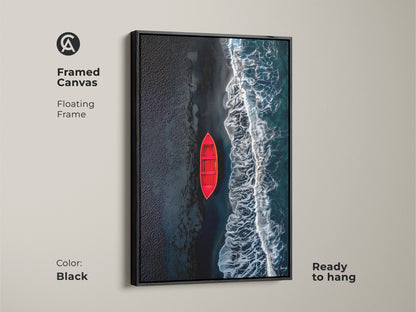 Framed canvas art featuring a red boat on a beach with black sand. The artwork has a sleek black floating frame. This canvas is ready to hang and will elevate any room's decor. A perfect addition to your art collection.