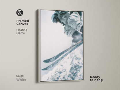 Framed canvas artwork capturing a skier's jump. The artwork features a white floating frame. This provides a clean and modern look. Ready to hang. Ideal for minimalist or contemporary spaces.