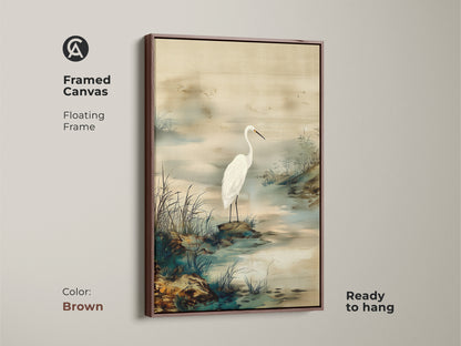 Brown framed canvas of an Egret bird in its habitat. Japandi style wall art provides a minimalist landscape. Ink wash egret painting featuring beige and green hues. Elegant bird art to hang.