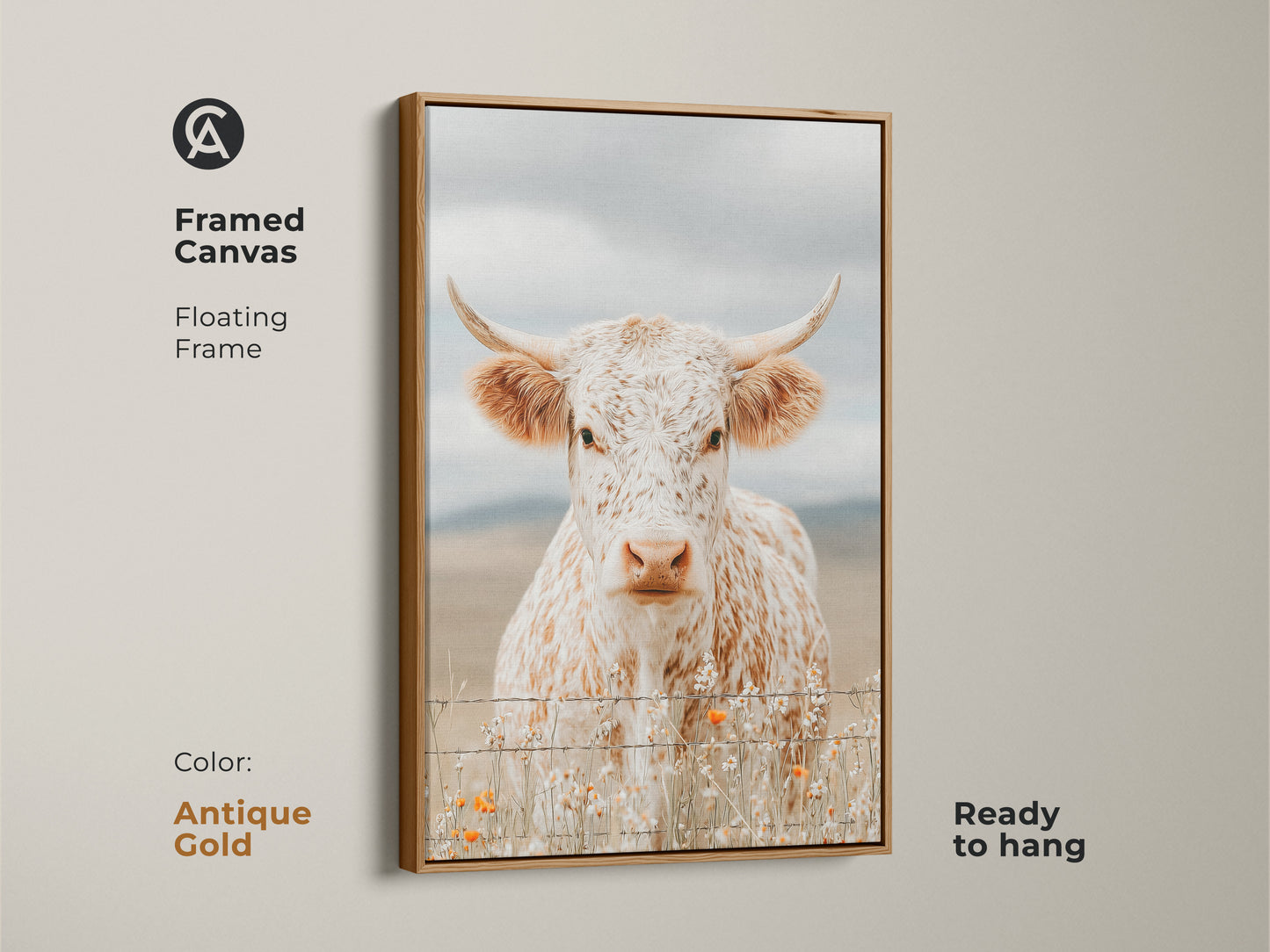 Framed canvas artwork of a white and brown speckled longhorn cow in an antique gold floating frame. The cow is standing behind a barbed wire fence. Orange wildflowers grow at the base. This framed art is ready to hang.