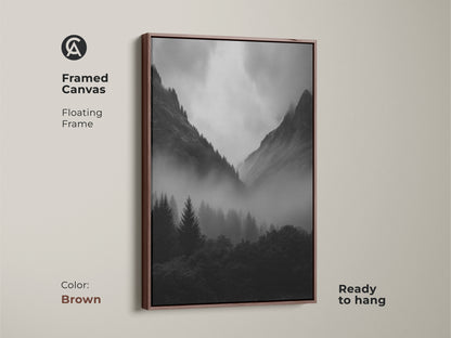 Framed monochrome forest canvas art in a brown floating frame. Black and white mountain landscape artwork ideal for modern nature decor. Misty pine trees create a serene nature artwork. A dramatic mountain scene.