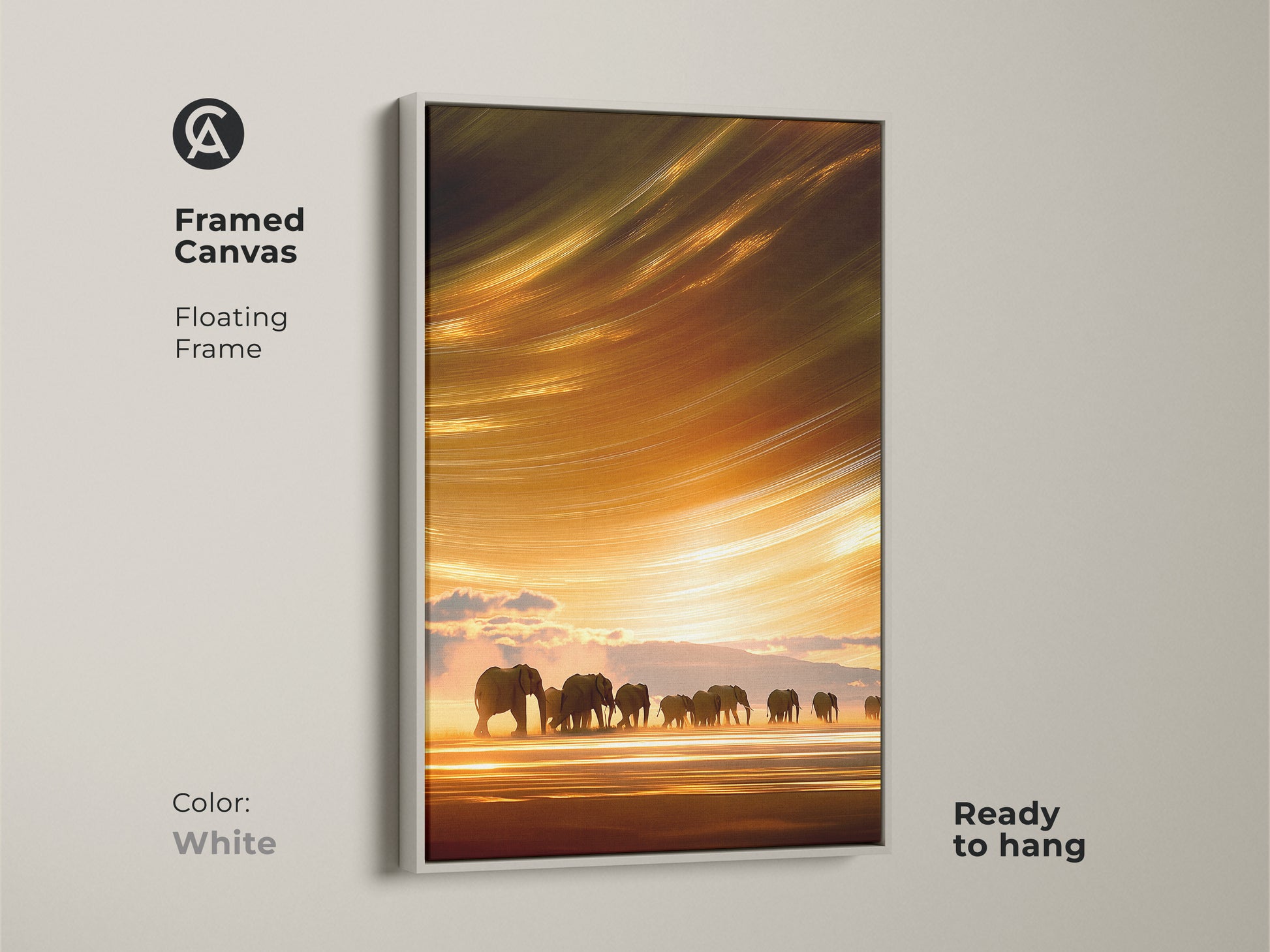 Framed canvas art showcases elephants on a savanna at sunset with a white floating frame. This abstract impressionistic art is a boho wildlife landscape. The serene orange and yellow hues make a great wall decor gift.