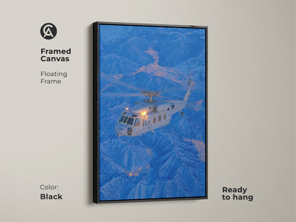 Framed canvas art featuring a helicopter over a blue mountain range. The black floating frame adds a touch of sophistication. This aviation-themed artwork is ready to hang and will enhance any space with its modern appeal.