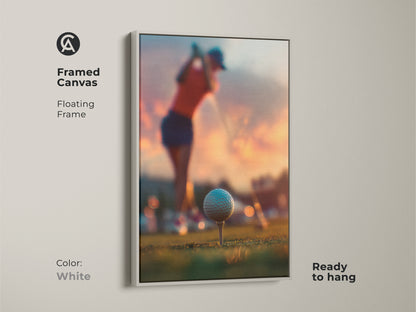 Framed canvas of golf art in a white floating frame. The artwork shows a golfer mid-swing. The golf ball is teed up ready for the game. Sunset adds a beautiful backdrop. Ready to hang golf art. Enhance your sports themed decor.