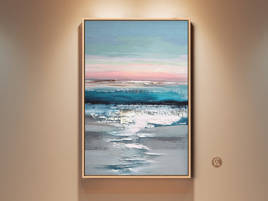 Framed abstract coastal canvas art displayed on a neutral wall. The teal blue and pink landscape print adds a modern touch. This textured ocean sky artwork is perfect for home decor. It creates a serene ambiance with its soft pastel hues and contemporary style.