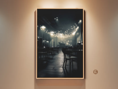 A captivating black and white photograph shows a dimly lit cafe. Strings of lights hang above empty tables creating a warm inviting glow. The artwork captures a quiet intimate atmosphere. This creates a timeless piece for your home decor.