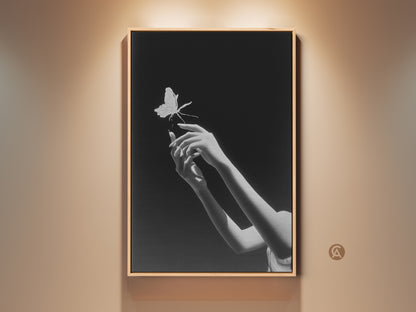 Elegant black and white art print featuring surreal hands reaching for a butterfly. This contemporary bedroom wall art adds a touch of symbolic nature to any modern home. It is a perfect gift for artists seeking minimalist and surreal wall decor. A fine art canvas print will bring an elegant aesthetic to your living space.