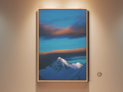 Winter Mountain Canvas Print showcases a snowy peak under a blue sky. Wispy clouds add depth to this landscape photography wall art. The contemporary nature artwork is framed adding a refined touch. A perfect housewarming gift for minimalist home decor.