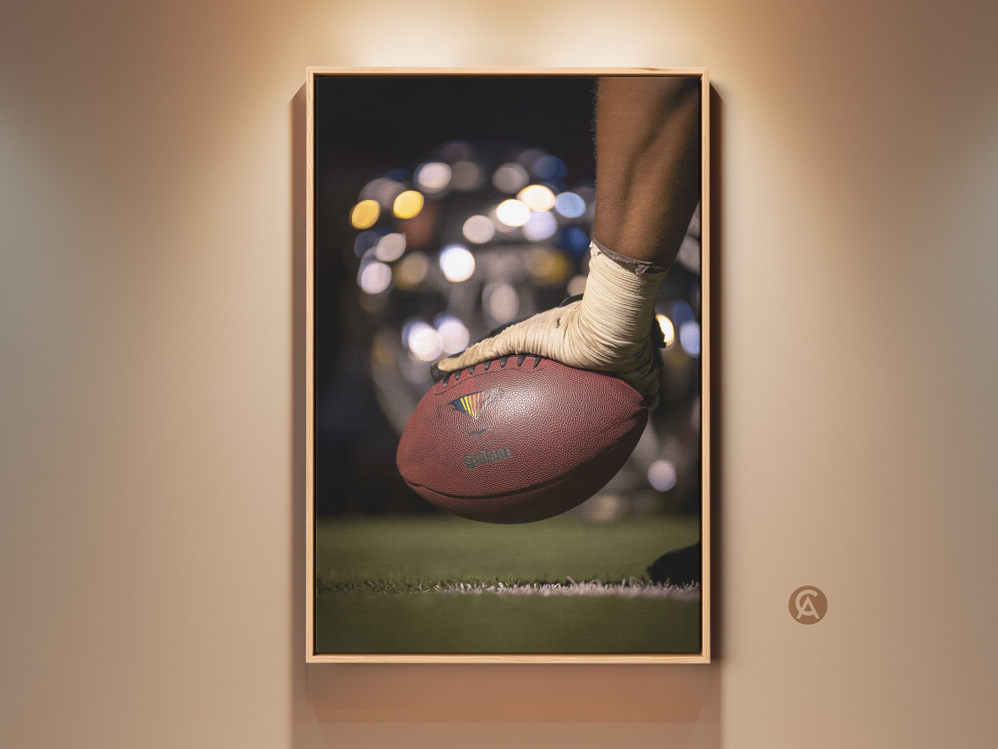 This sports wall artwork features a close-up of a football. A player's hand is shown ready for action. The brown and green tones give it a contemporary feel. Perfect man cave decor. This canvas print captures the essence of the game. Ideal gift for sports fans seeking athletic energy in their space.
