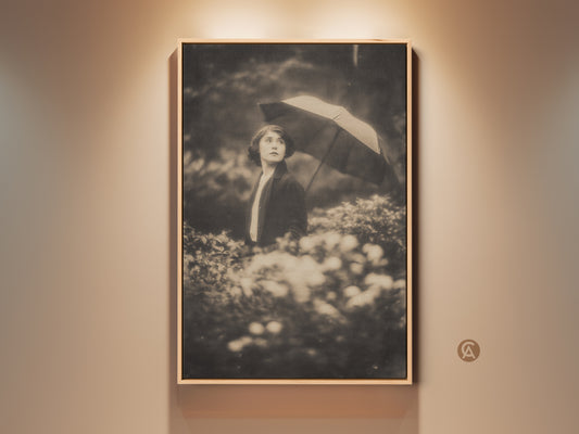 Framed vintage photograph art print. A woman stands among flowers holding an umbrella. Sepia tones add a timeless feel. Displayed under warm lighting. Perfect wall decor. Enhance your home with this beautiful artwork.