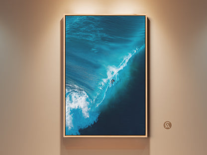 Eye-level shot of a surfer riding a massive blue wave. This framed artwork captures the power and beauty of the ocean. Perfect for coastal decor. Add a touch of the sea to your space with this surfing art print. Order yours today