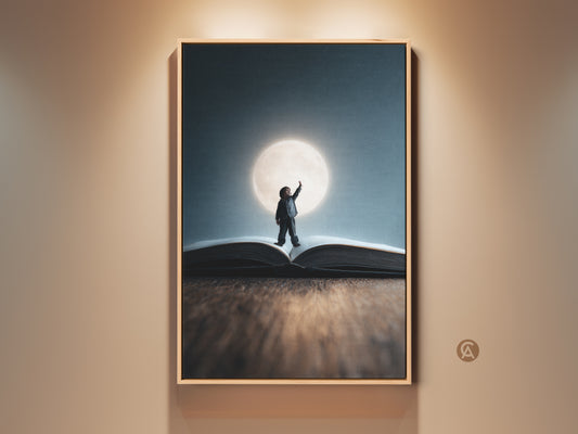 Surreal child dream art print framed in a light wood floating frame. This fantasy wall art features a child reaching for the moon atop an open book. Conceptual nursery decor is rendered in blue yellow and teal tones.