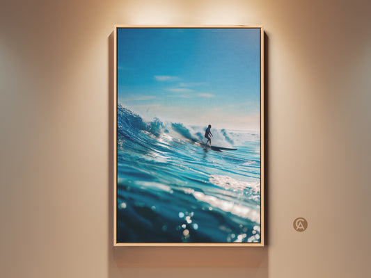 A framed canvas print showcases a surfer riding a majestic blue wave. The artwork captures the power and beauty of the ocean. Perfect wall art for surf enthusiasts. The oak floating frame enhances this ocean scene. Ready to hang and enjoy.
