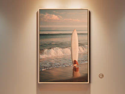 Framed surfboard art on a sandy beach. The artwork captures a serene ocean scene. Gentle waves are rolling in. The surfboard stands upright creating a focal point in the composition. A perfect piece of coastal art for any home.