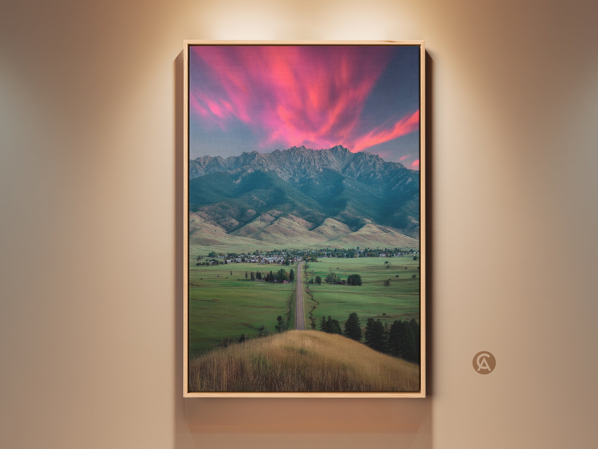 Framed pink sunset mountain canvas art displayed indoors. The landscape wall art brings a touch of modern farmhouse decor to any room. Ideal as scenic bedroom wall art. Perfect as a housewarming gift for outdoor lovers. It adds a rural town charm to residential wall decor
