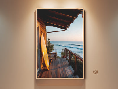 A framed coastal art piece showcases a surfboard on a porch. The artwork captures a serene ocean view at sunset. This framed canvas adds a touch of beach house style. It is perfect for coastal home decor. Ready to hang and enjoy this ocean art print.