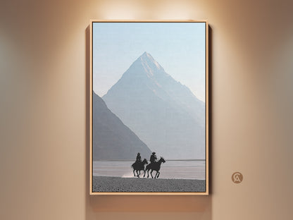 Minimalist Western art print of cowboys on horseback. Misty blue mountain canvas creates a serene scene. Perfect home and living room wall decor. Ideal for rustic and modern spaces adding a touch of adventure. Equestrian artwork evokes a peaceful mountain scene.