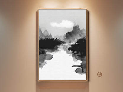 Framed black white ink wash art print on a beige wall. This mountain river landscape canvas adds minimalist nature wall decor to any space. The Japanese Sumi-e style artwork brings a calm aesthetic to your home or office. This fine art print enhances your room's ambiance with its serene monochrome beauty.