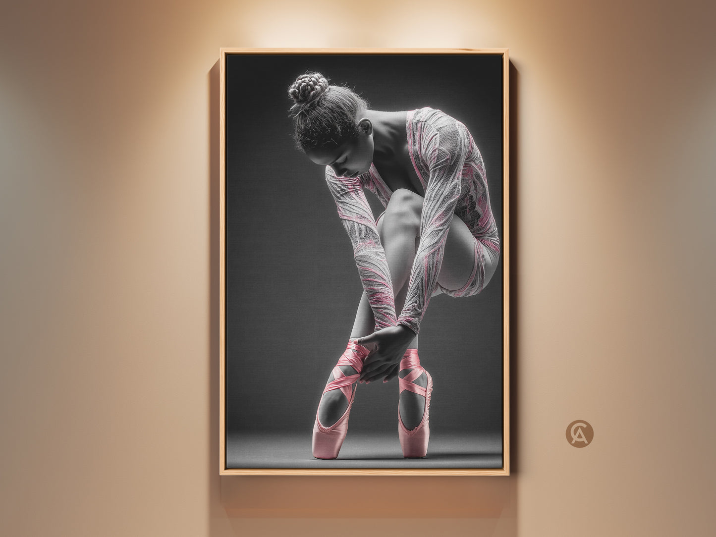 Framed ballerina artwork on a wall. This framed canvas features a floating frame. The frame is oak. The artwork shows a ballerina tying her pink ballet shoes. Buy framed art for your home today.