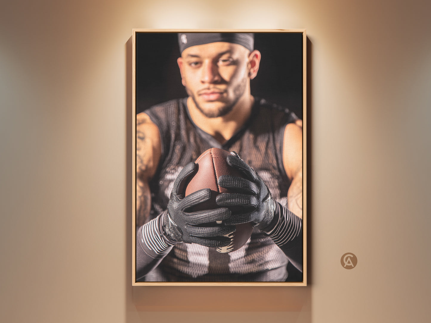 Framed American Football art print displayed on a tan wall. This athlete portrait brings intense sports decor to any room. The brown frame enhances the artwork. Ideal for a home gym or man cave. Get this sports wall decor today as a gift for a football fan.
