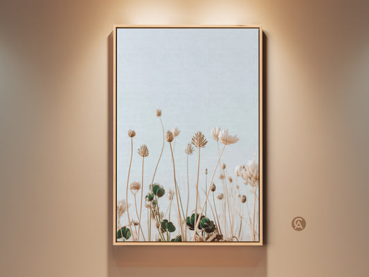 Framed boho wildflower art print in cream and light blue tones. The minimalist floral artwork enhances bedroom decor. A serene botanical piece brings nature indoors. Perfect as a housewarming gift for plant lovers.  It is ideal for minimalist interiors. This canvas print adds a delicate artistic touch to residential spaces.