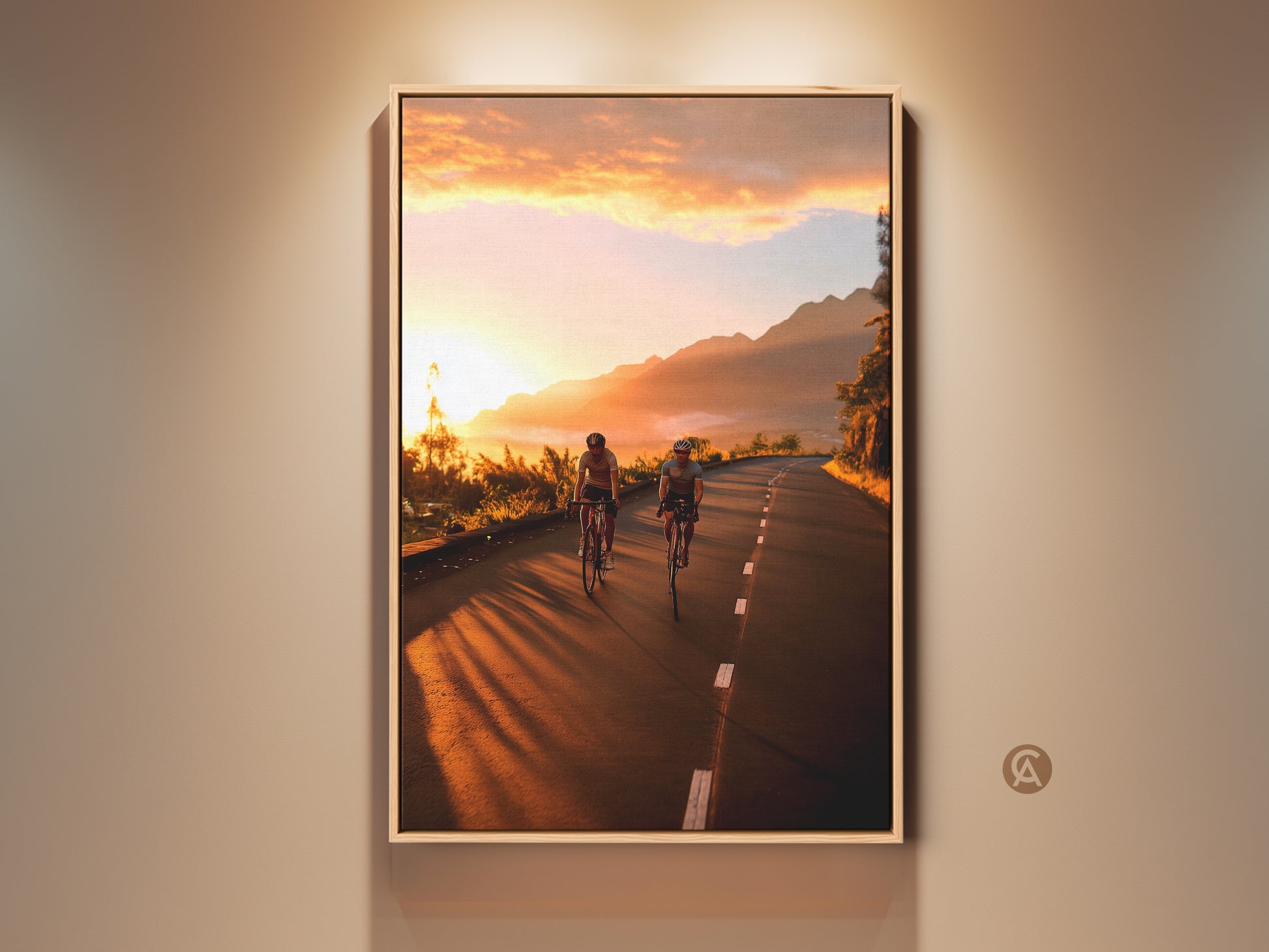 Cycling wall art print featuring a mountain road at sunset. The warm yellow and orange sky creates a golden hour glow. This landscape photography captures the thrill of adventure. It is a perfect gift for cyclists and travel enthusiasts. Enhance your home with this motivational wall art.