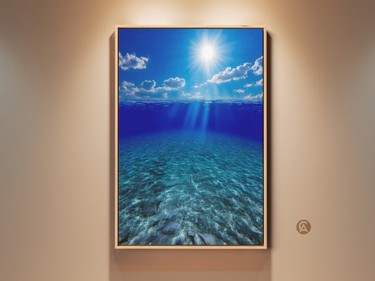 Framed coastal canvas artwork featuring underwater sunbeams in deep blue ocean. This photorealistic seascape art is perfect beach house wall decor. The calming blue tones and sunlit scene bring a serene touch to any residential space. A great housewarming gift for ocean and beach lovers.