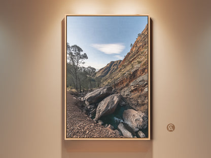 Rustic wall art featuring a rocky mountain landscape with gnarled trees. Sky blue hues enhance this nature photography print. Perfect as a gift for hikers or as home decor. The terracotta tones bring warmth to any space. This artwork captures the essence of outdoor adventure.