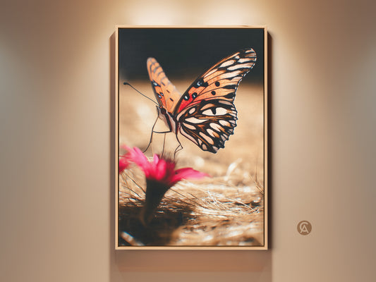 Framed orange butterfly art on a wall. This nature photography print features a realistic insect close up. The boho canvas print adds vibrant color to bedroom decor. A perfect gift for nature lovers. The artwork captures the intricate details of the butterfly's wings with floral accents.